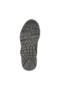 Semelle de chaussure en caoutchouc noir présentant des motifs de crampons profonds, des formes en zigzag et en triangle pour l'adhérence. Bords lisses avec un design à bout rond.