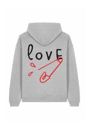 Haut à capuche gris avec un cordon de serrage. Le dos présente un texte brodé noir et rouge "amour" ainsi qu'un design de pin's de sécurité rouge. Texture douce.
