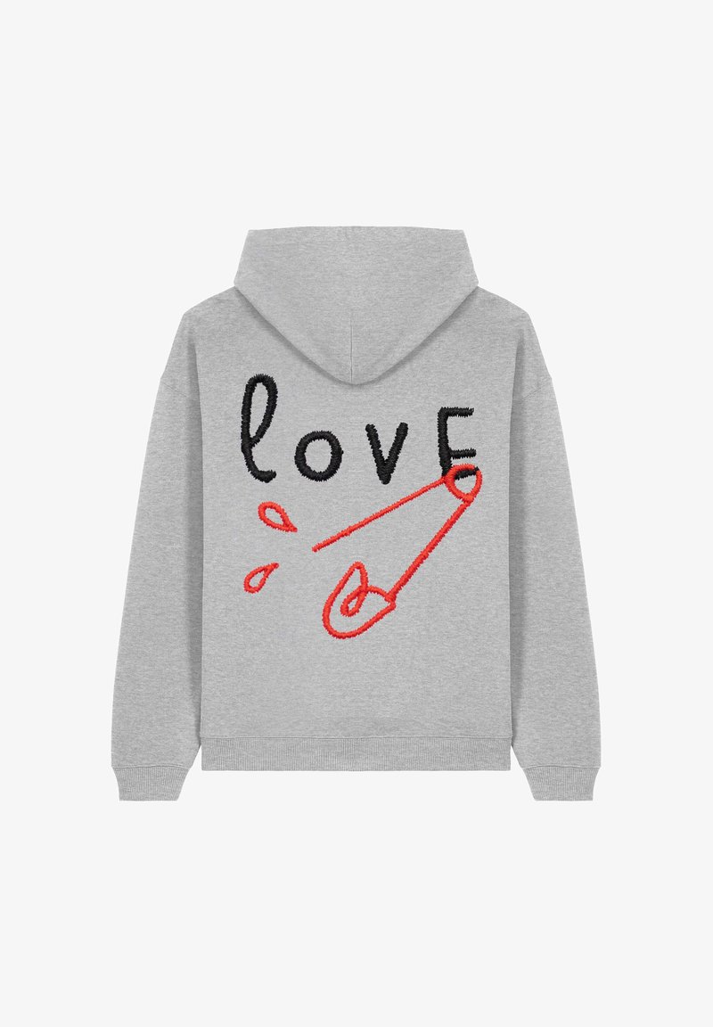 Haut à capuche gris avec un cordon de serrage. Le dos présente un texte brodé noir et rouge "amour" ainsi qu'un design de pin's de sécurité rouge. Texture douce.