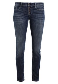 Vaqueros de mezclilla azul oscuro con corte ajustado, que cuentan con una cremallera de cinco botones, costuras visibles y dos bolsillos delanteros. Textura suave con un acabado desgastado.