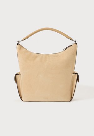 Borsa hobo in camoscio color cuoio con unico manico curvo, tasche laterali e chiusura superiore con zip, esposta su sfondo bianco.