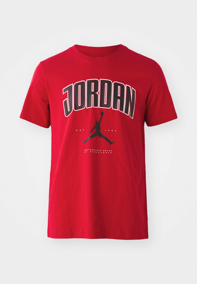 Camiseta de algodón roja con el texto "JORDAN" en negro y una gráfica de silueta de una figura saltando con un baloncesto. Mangas cortas, cuello redondo.