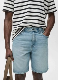 Bermude din denim de culoare bleu deschis, cu o croială dreaptă, design cu cinci buzunare și o ușoară decolorare, asortate cu un top tricotat cu dungi și mâneci scurte.