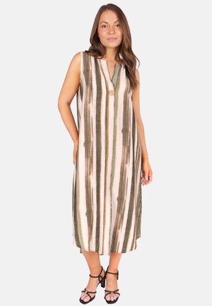 Femme portant une robe sans manches longueur genoux avec des rayures verticales vertes et beiges et un bouton en bois près de l'encolure.