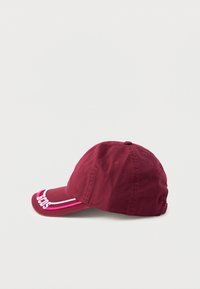 Gorra de béisbol color burdeos hecha de algodón, con visera curvada y acentos bordados en rosa y blanco, y orificios de ventilación en la parte superior.