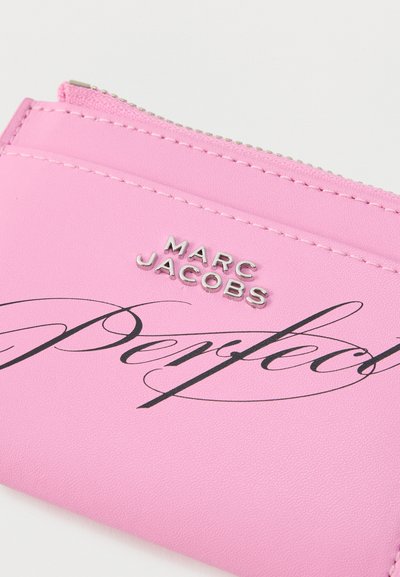Ροζ δερμάτινη θήκη με φερμουάρ, ασημί λογότυπο "MARC JACOBS" και μαύρο καλλιγραφικό κείμενο "Perfect" στο μπροστινό μέρος.