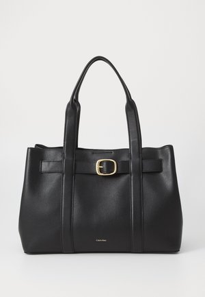 Schwarze Ledertasche mit zwei Henkeln, einem vorderen Gürtel mit goldener Schnalle und kleinem Calvin Klein Logo nahe der unteren Mitte.