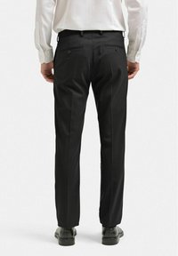Svarta kostymbyxor med skräddarsydd passform, med två bakfickor med knappstängning och en slät, formell tygtextur.