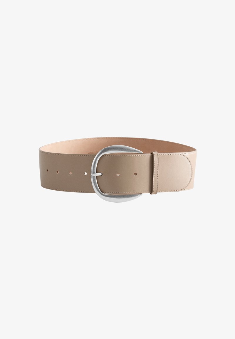 Ceinture large en cuir beige avec grande boucle argentée incurvée et plusieurs trous de réglage.