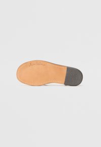 Lærsåle med en beige base og en mørk grå hæl. Har søm langs kanten og "Sam Edelman" preget på overflaten.