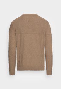 Ruskea neulottu pusero pitkillä hihoilla, pyöreällä pääntiellä, teksturoidulla kankaalla ja vaakasuoralla saumalla yläselässä.