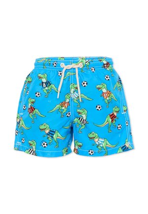 Niebieskie szorty z kreskówkowymi zielonymi dinozaurami w koszulkach piłkarskich i czarno-białymi piłkami nożnymi rozrzuconymi po tkaninie.