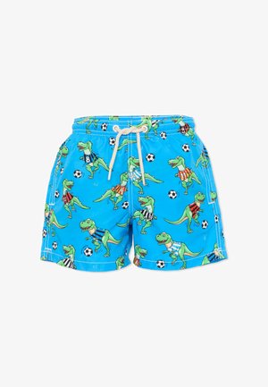 Shorts bleus avec des dinosaures verts en dessin animé portant des maillots de football et des ballons de football noir et blanc dispersés sur le tissu.