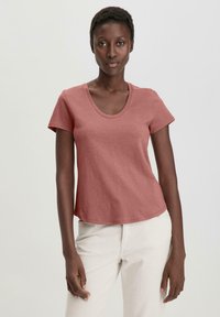 Lyhythihainen, pyöreäkauluksinen t-paita hillityssä ruusunsävyssä. Valmistettu pehmeästä, kevyestä kankaasta, jossa on rento istuvuus ja siisti, kaareva helma.