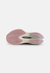 Sko såle med et teksturert hvitt og rosa gummidesign, som har et heksagonalt mønster og spor for grep. Hastighetsrull-teknologi er nevnt.