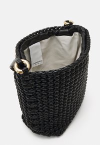 Czarna pleciona torebka o teksturowanej powierzchni, z złotymi elementami i miękkim, jasnym wnętrzem.