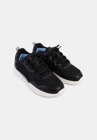 Baskets de sport noires dotées d'une tige en maille respirante, d'accents en cuir lisse, d'une semelle intermédiaire blanche et de lacets noirs, le tout agrémenté d'un intérieur bleu.
