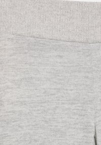 Tissu gris à texture lisse avec une ceinture côtelée. La surface présente un motif subtil de fils clairs et foncés.