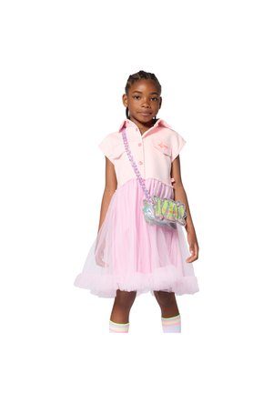 Ροζ φόρεμα πόλο με κοντά μανίκια και φούστα από τούλι, συνδυασμένο με ολογραφική τσάντα χιαστί και ριγέ κάλτσες μέχρι το γόνατο.