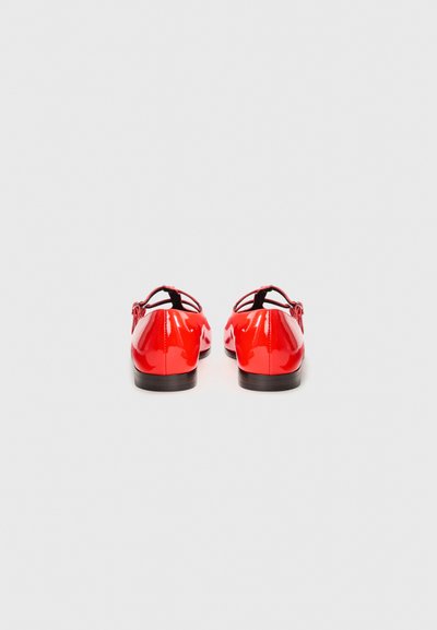 Red patent leather shoes with a smooth finish, featuring a low black heel and delicate ankle straps for secure fitting.