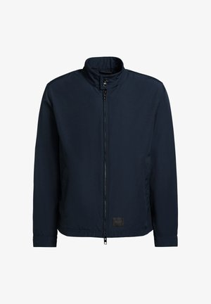 Lehká námořnicky modrá bunda s límcem na stojáka, předním zipem, zapínacím páskem na krku a dlouhými rukávy, s nápisem "KHUJO" na lemu.