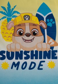 T-shirt con un cane dei cartoni animati che indossa un casco giallo, una tavola da surf blu, un ananas e la scritta "SUNSHINE MODE" in grassetto blu.