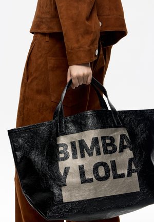 Duża czarna torba na ramię o błyszczącej teksturze, z wyraźnym beżowym panelem z napisem "BIMBA Y LOLA" grubymi czarnymi literami.