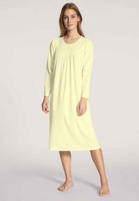 Abito da notte a maniche lunghe in morbido tessuto giallo chiaro. Presenta un collo a giro, dettagli arricciati sotto il seno e un design dritto, lungo fino alla caviglia.