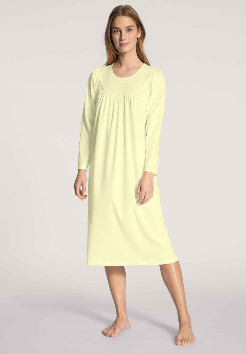 Abito da notte a maniche lunghe in morbido tessuto giallo chiaro. Presenta un collo a giro, dettagli arricciati sotto il seno e un design dritto, lungo fino alla caviglia.