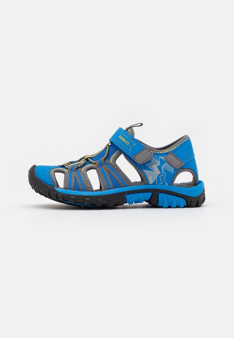 Sandale fermée pour enfants bleu et gris avec brides velcro, semelle en caoutchouc noire et motif en zigzag sur le côté.