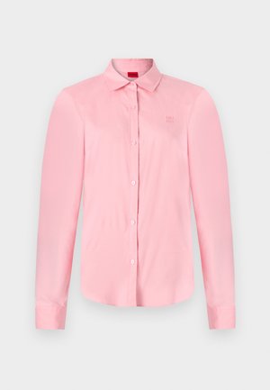 Lichtroze langemouw shirt met knoopsluiting en een kraag; heeft een subtiele geborduurde rand op de borst en een gladde stofstructuur.