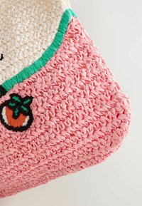 Sac à tote tissé avec une base rose texturée, une partie supérieure blanche, un contour vert et des broderies de fruits orange.