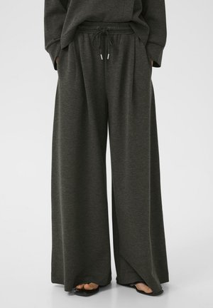 Mörkgrå vida sweatpants i mjukt tyg, med elastisk midja och snörning samt sidofickor.