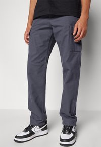 Pantalons cargo gris avec poches latérales, en coton. Caractéristiques : coupe ample, design à jambe droite et couture renforcée.