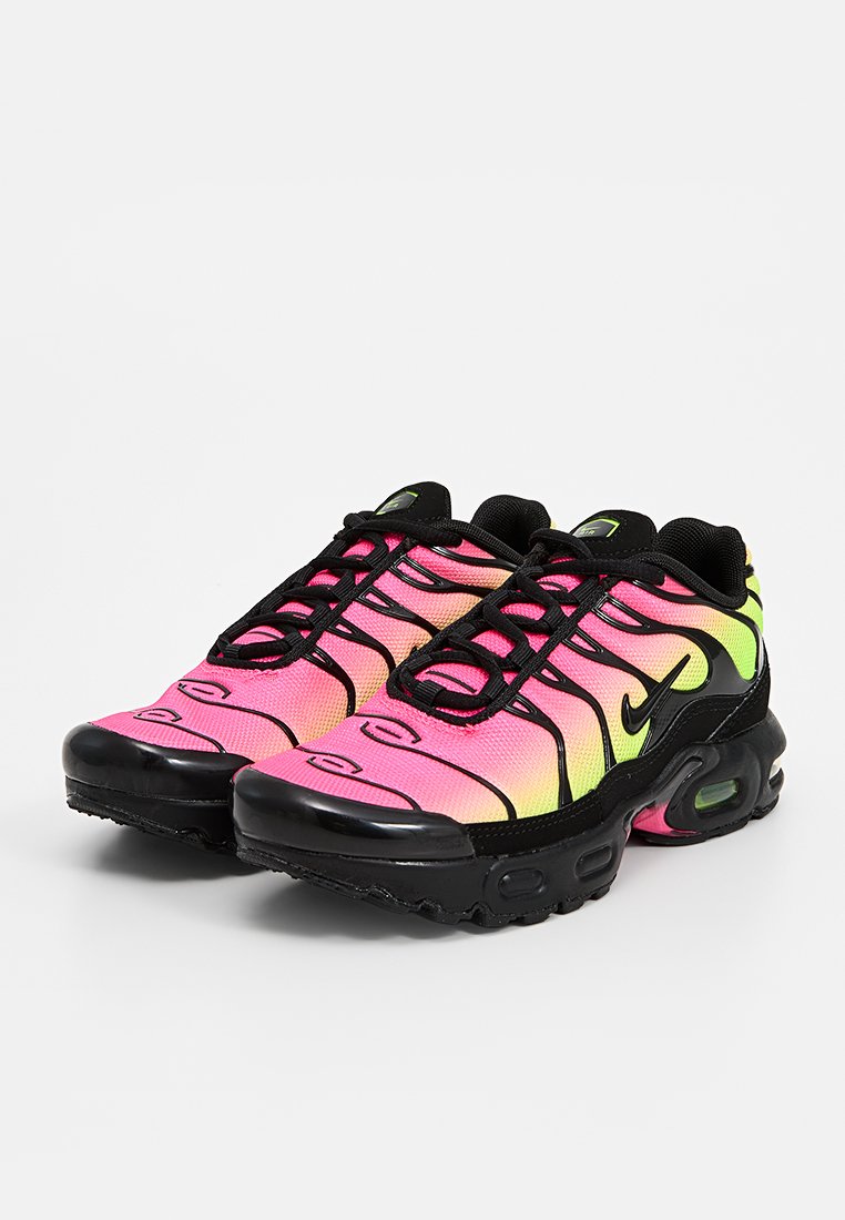 Zapatillas Nike con suela de goma negra, con parte superior en degradado rosa y amarillo, cordones negros y detalles ondulados dinámicos en los laterales.