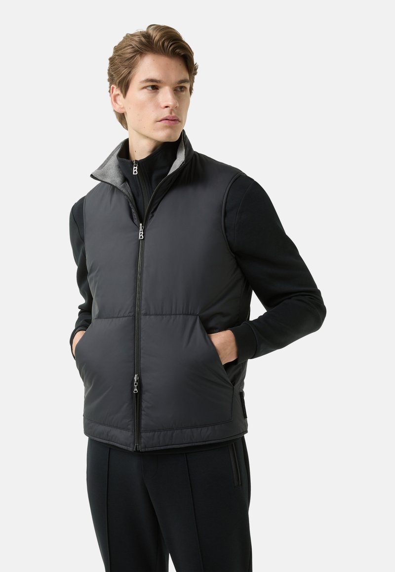 Czarna pikowana kamizelka z wysokim kołnierzem i szarym podszyciem, z przednim zamkiem błyskawicznym, bocznymi kieszeniami oraz lekkim krojem.