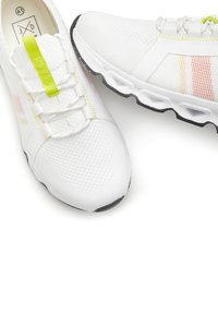 Weiße Sportschuhe mit einem Mesh-Obermaterial, kontrastierenden gelben und orangen Streifen, strukturiertem Absatz und runden Schnürsenkeln. Leichtes und flexibles Design.