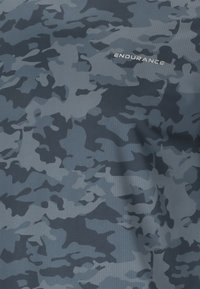 Texture de tissu camouflage gris foncé et clair avec le mot « ENDURANCE » imprimé en lettres majuscules blanches.
