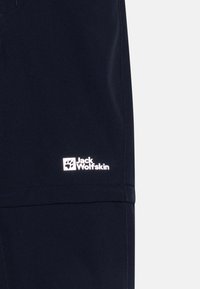 Temno modri kratki hlače z gladko teksturo, ki imajo bel logotip Jack Wolfskin na levi nogi in preprost dizajn s čistimi linijami.