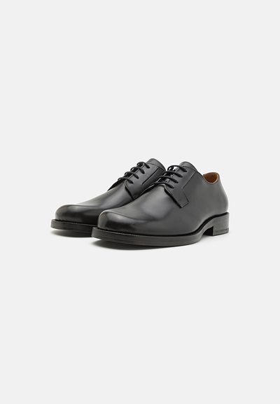 Scarpe da uomo in pelle nera, con punta arrotondata, finitura liscia, allacciatura con cinque occhielli e tacco basso impilato. Design classico e minimalista.