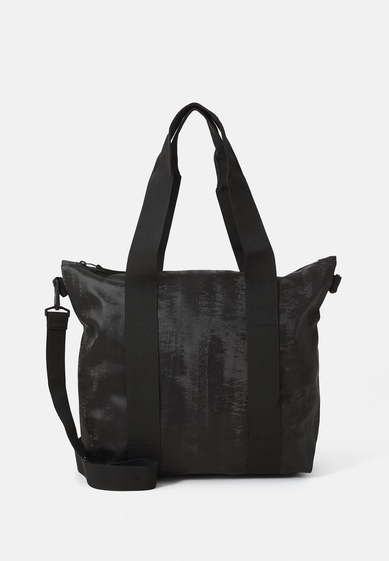 Svart totebag med teksturert stoff, doble topphåndtak og en avtakbar skulderrem. Har glidelås for sikker oppbevaring.