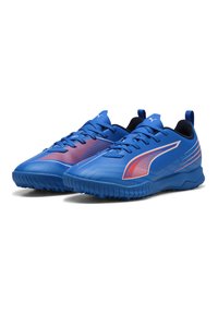 Chaussures de sport bleues avec une tige synthétique lisse, des accents noirs et une semelle texturée arborant des éléments de design rouges et bleus.