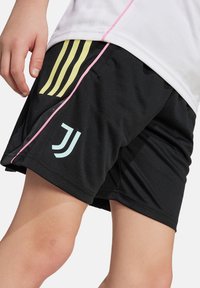 Schwarze Sportshorts mit gelbem Drei-Streifen-Design, rosaner Akzentnaht und hellblauem Logo auf der Seite zur Kennzeichnung.