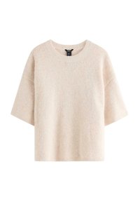 Kortærmet sweater i lys beige, lavet af blødt stof. Har ribkant ved halsen og løs pasform med en tekstureret, let fluffet overflade.
