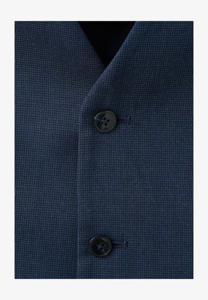 Tissu de blazer bleu marine texturé avec un motif à carreaux subtil. Présente un bouton noir à la fermeture et un détail de couture visible.