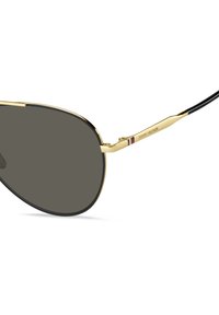 Ochelari de soare aurii de tip aviator cu lentile gri, accente negre și un profil subțire. Prezintă un branding subtil pe lateral și linii elegante, curbate.