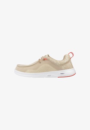 Sneaker beige senza lacci con suola bianca, linguetta rossa e dettagli rossi, pannello laterale traforato e colletto imbottito alla caviglia con motivo sottile.