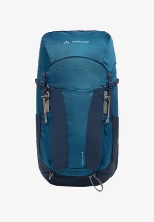 Sac à dos de randonnée bleu et marine avec des sangles réglables, des poches latérales en maille et un rabat supérieur. Il est doté d'un tissu texturé et d'un logo de marque.
