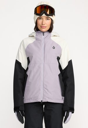 Veste de ski avec un corps violet clair, des manches noires et des accents crème. Fabriquée en matériau imperméable, elle possède une fermeture éclair à l'avant et un détail de logo.