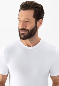 Witte T-shirt met korte mouwen en een ronde hals, gemaakt van soepel materiaal, met een aansluitend ontwerp en subtiele textuur.